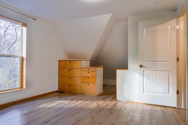 bonus room with light hardwood / wood-style floors and vaulted ceiling