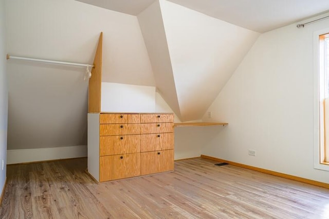 bonus room with light hardwood / wood-style flooring and vaulted ceiling