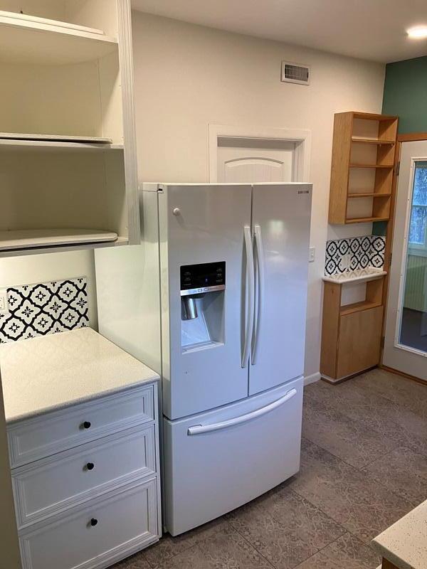 kitchen with light tile patterned floors and white refrigerator with ice dispenser