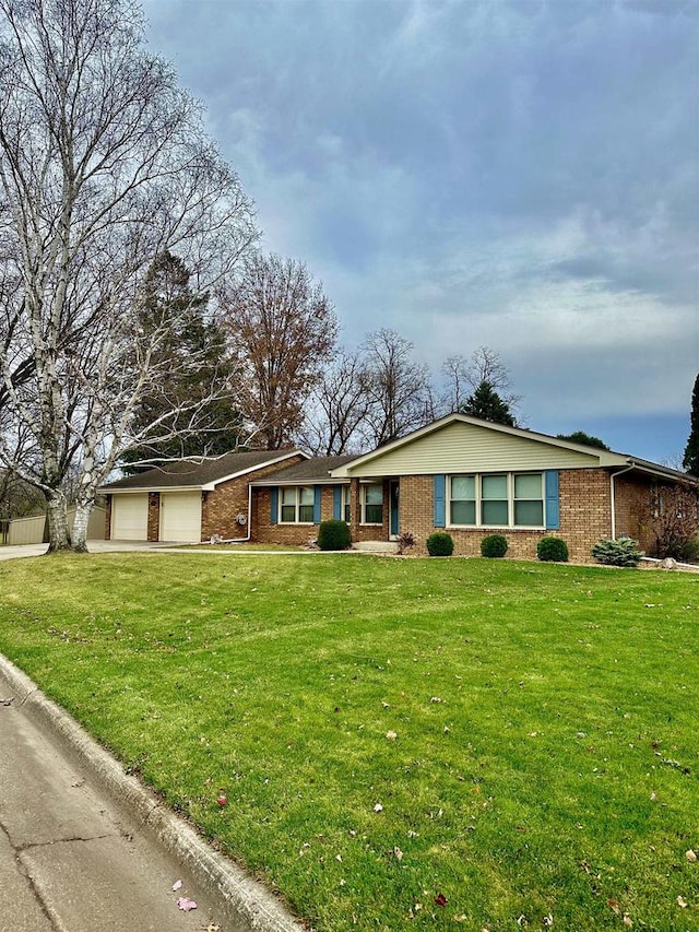 ranch-style house featuring a front yard and a garage