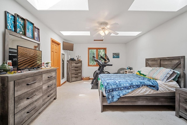 carpeted bedroom featuring a skylight and ceiling fan