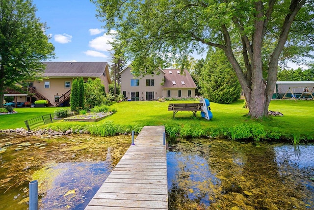 view of dock featuring a lawn and a water view