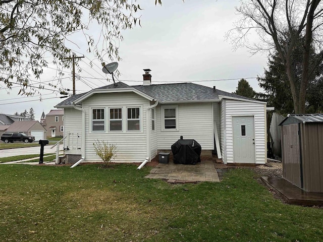 back of house featuring a yard and a shed