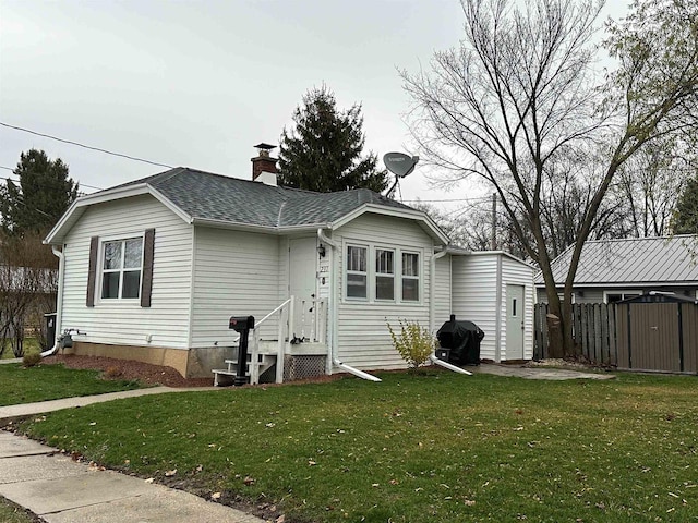 rear view of property featuring a lawn