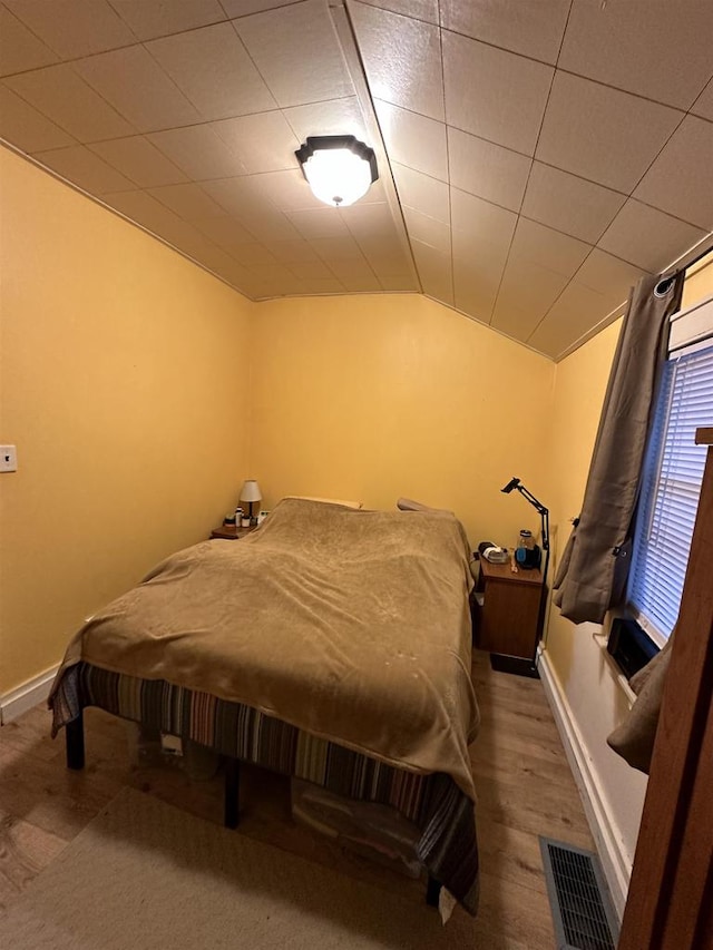 bedroom featuring wood-type flooring and lofted ceiling