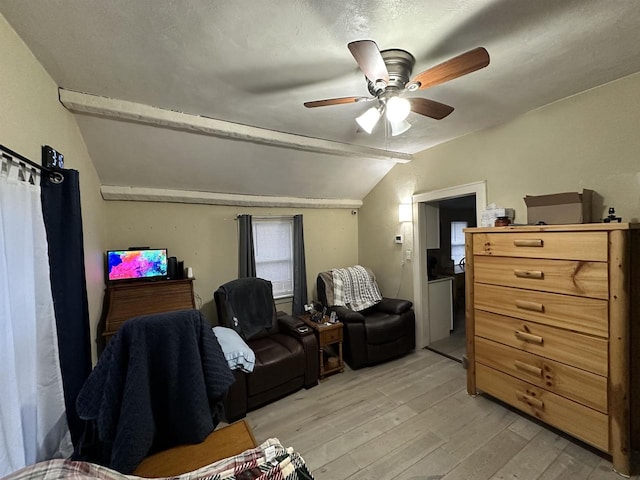 interior space with ceiling fan, light hardwood / wood-style floors, a textured ceiling, and vaulted ceiling