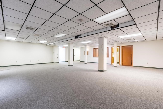 basement featuring a paneled ceiling and carpet