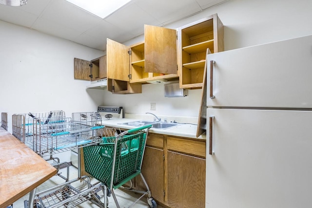 kitchen with a paneled ceiling, white fridge, and sink