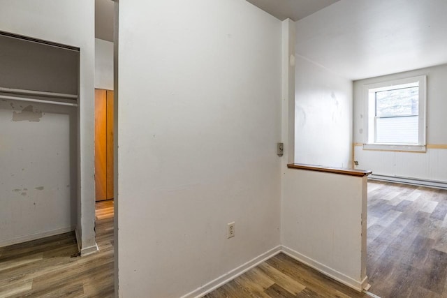 interior space with hardwood / wood-style floors, a closet, and a baseboard radiator