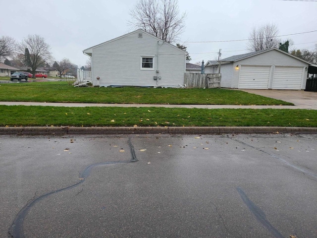 view of side of home featuring a yard, an outdoor structure, and a garage