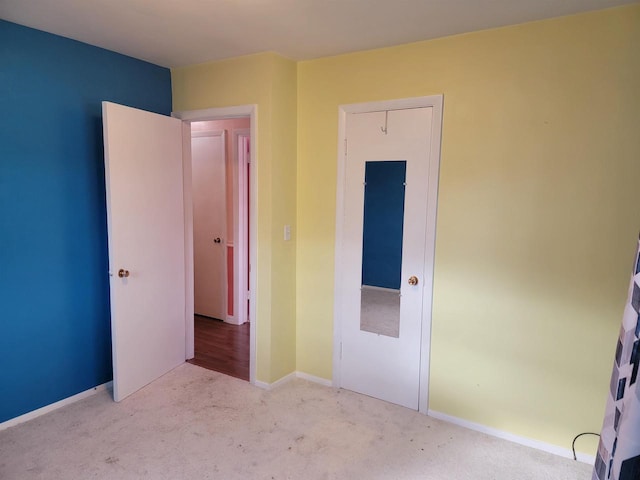 unfurnished bedroom featuring light carpet and a closet