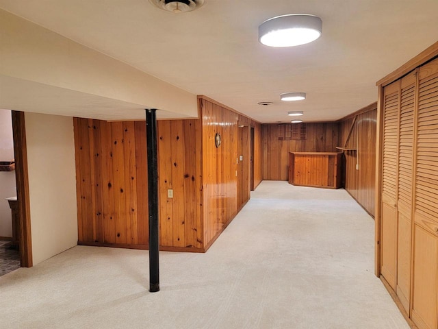 interior space featuring light carpet and wood walls