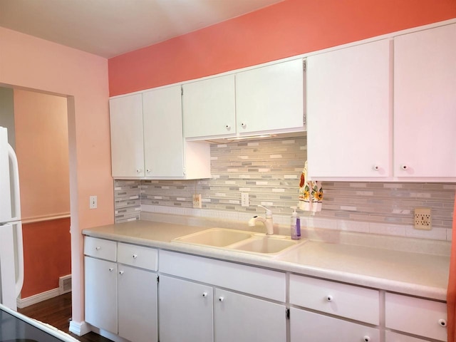 kitchen with dark wood-type flooring, white cabinets, sink, tasteful backsplash, and white fridge