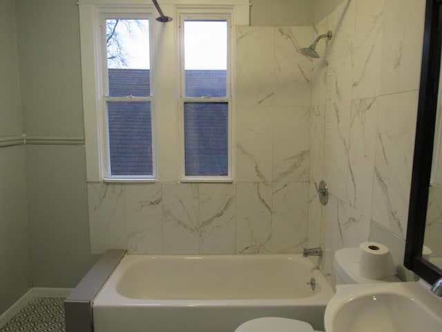 full bathroom with toilet, tiled shower / bath combo, and sink