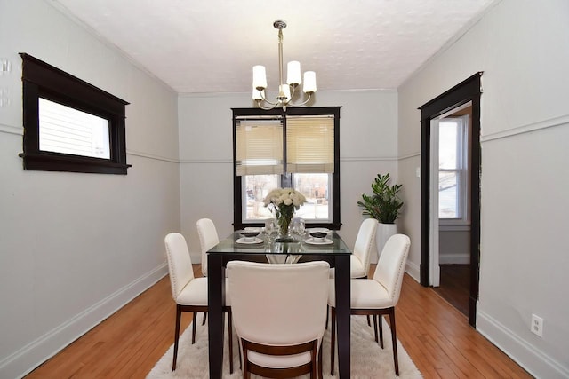 dining space featuring a notable chandelier, crown molding, hardwood / wood-style floors, and a wealth of natural light