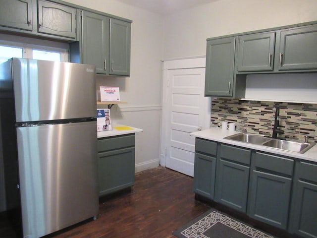 kitchen featuring sink, stainless steel fridge, backsplash, and dark hardwood / wood-style floors