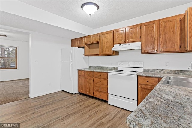 kitchen featuring a textured ceiling, sink, white appliances, and light wood-type flooring