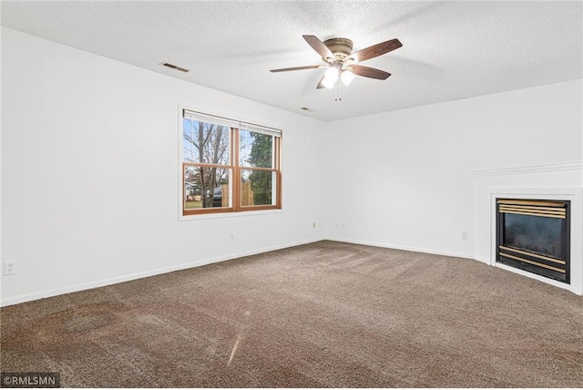 unfurnished living room featuring carpet, ceiling fan, and a textured ceiling