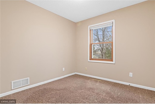 spare room featuring carpet and a textured ceiling