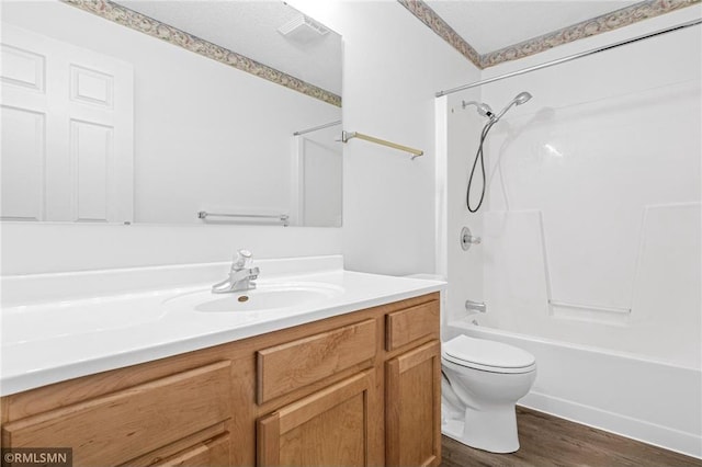 full bathroom with bathtub / shower combination, vanity, hardwood / wood-style flooring, and toilet