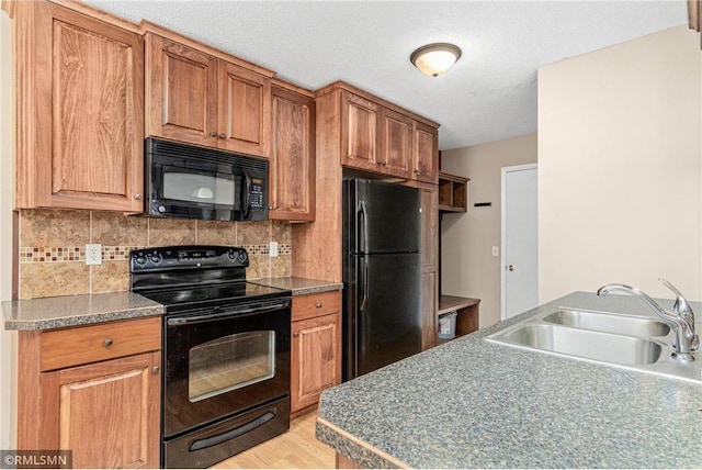 kitchen with black appliances, sink, light hardwood / wood-style flooring, a textured ceiling, and tasteful backsplash