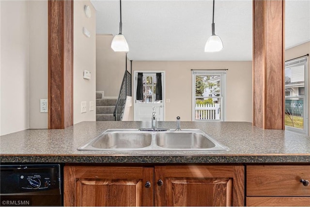 kitchen with dishwasher, sink, and hanging light fixtures