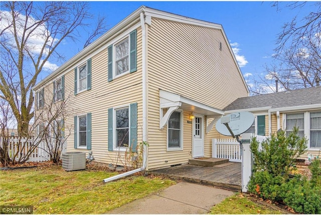 view of front of home featuring central AC unit and a front yard