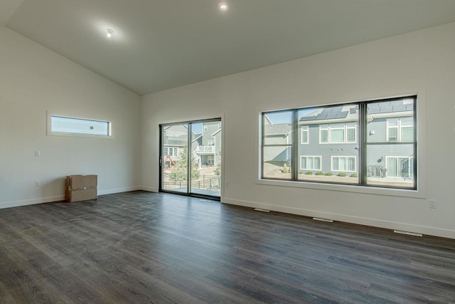 empty room with high vaulted ceiling and dark hardwood / wood-style floors