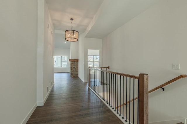 corridor featuring a chandelier and dark wood-type flooring