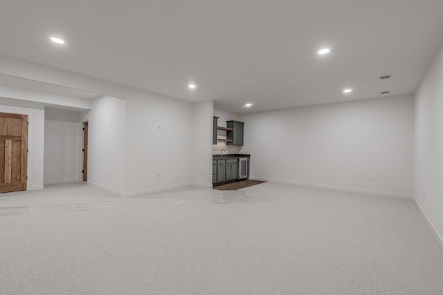 basement featuring light carpet and sink