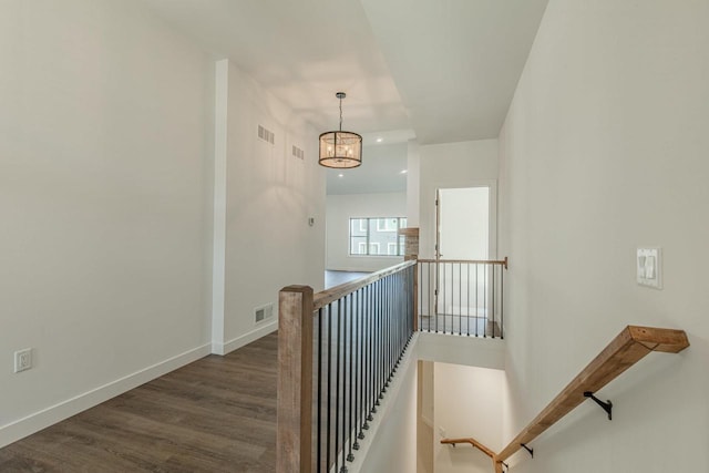 stairway with a chandelier and wood-type flooring