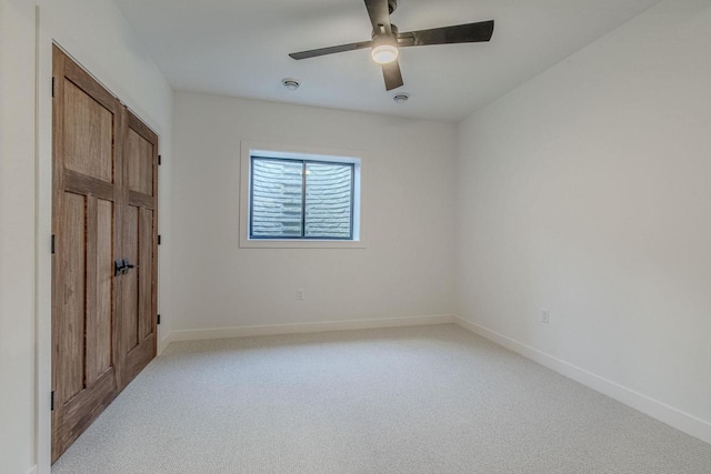 empty room with ceiling fan and light colored carpet