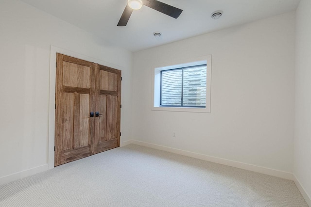 empty room with ceiling fan and light colored carpet