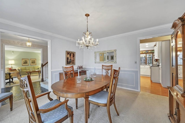 dining area featuring crown molding, light carpet, and an inviting chandelier