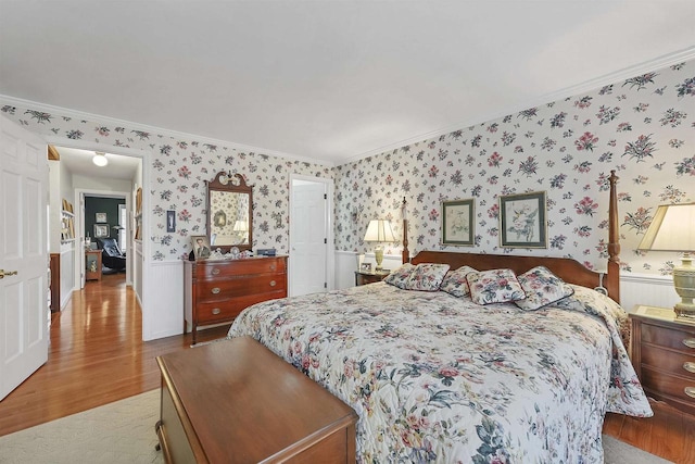 bedroom with light wood-type flooring and crown molding