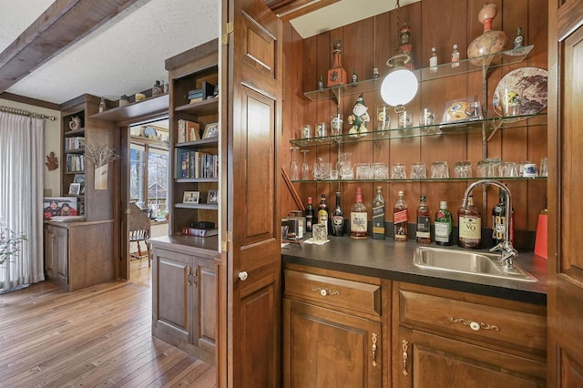 bar featuring beamed ceiling, wood-type flooring, and sink