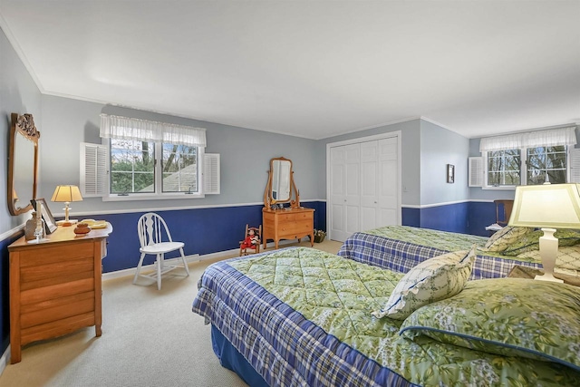 carpeted bedroom featuring crown molding and a closet