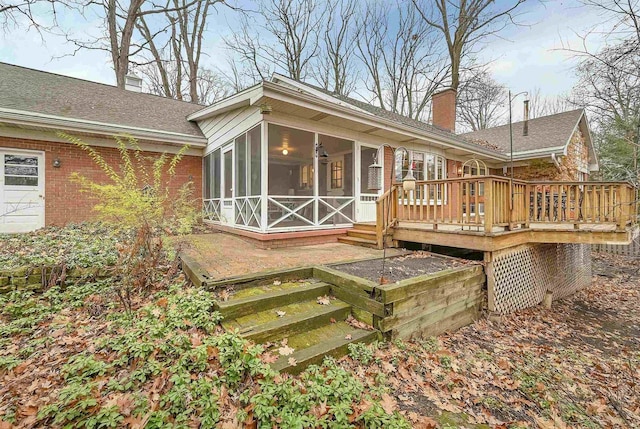 back of house featuring a wooden deck and a sunroom