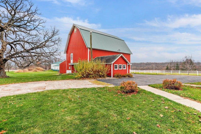 view of outbuilding featuring a lawn and a rural view