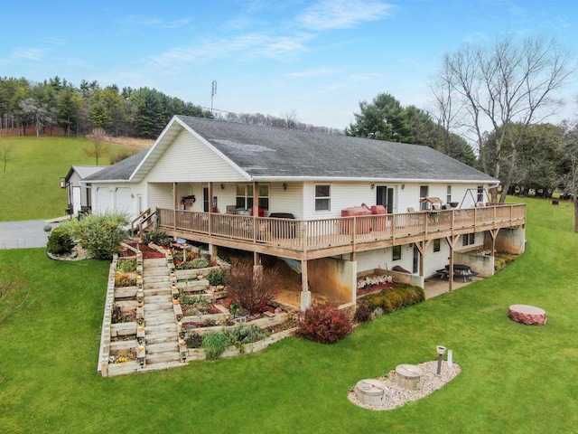 rear view of property featuring a patio, a wooden deck, and a lawn