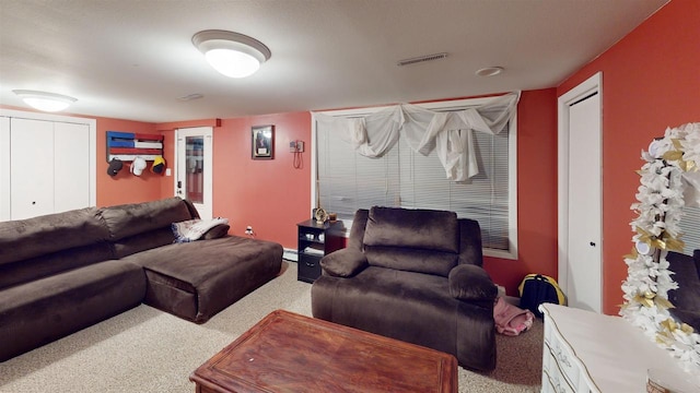 living room featuring a baseboard heating unit and light colored carpet