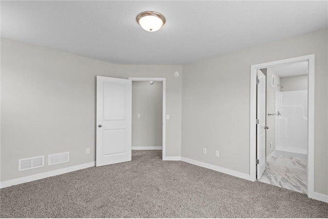 unfurnished bedroom with light colored carpet and a textured ceiling