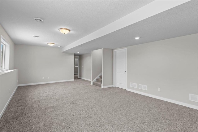 basement with carpet flooring and a textured ceiling