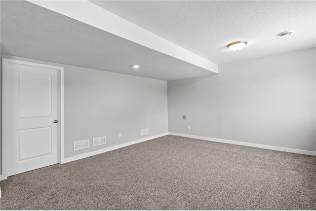 carpeted empty room featuring a textured ceiling