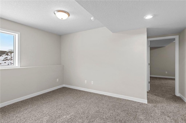 carpeted empty room with a textured ceiling