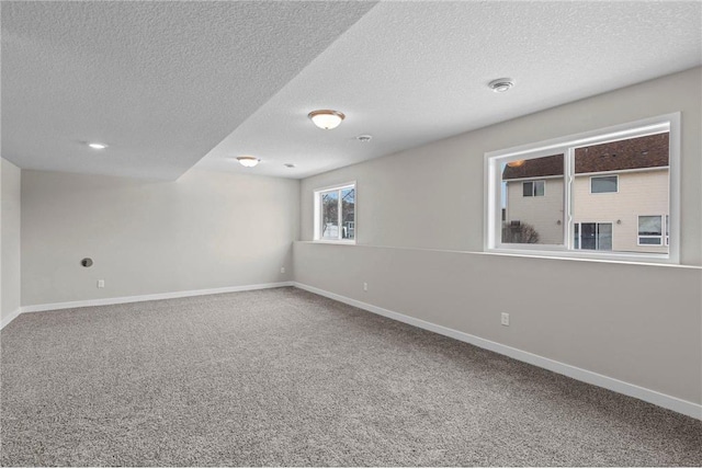 carpeted spare room featuring a textured ceiling