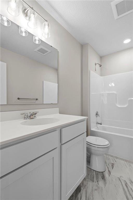 full bathroom with vanity, toilet, tub / shower combination, and a textured ceiling