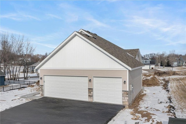 snow covered property with a garage