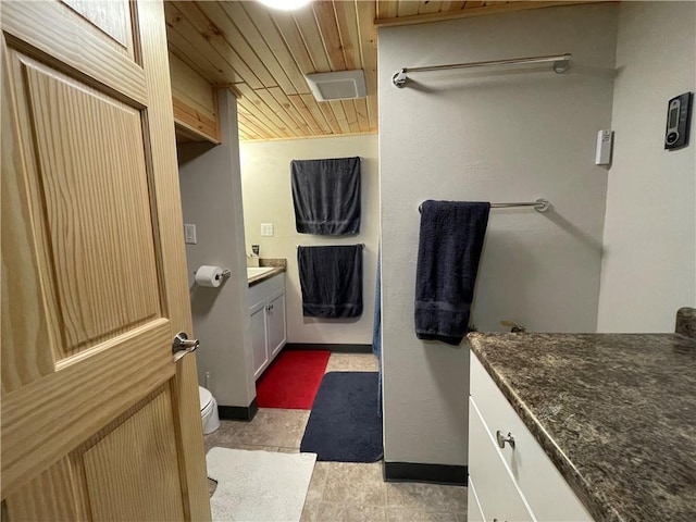 bathroom featuring tile patterned flooring, vanity, toilet, and wooden ceiling