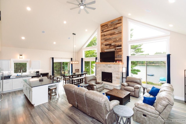 living room with ceiling fan, wood-type flooring, sink, and a wealth of natural light